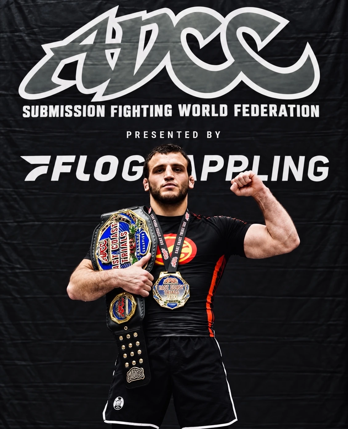 Grappler holding championship belts and medals in front of an ADCC backdrop