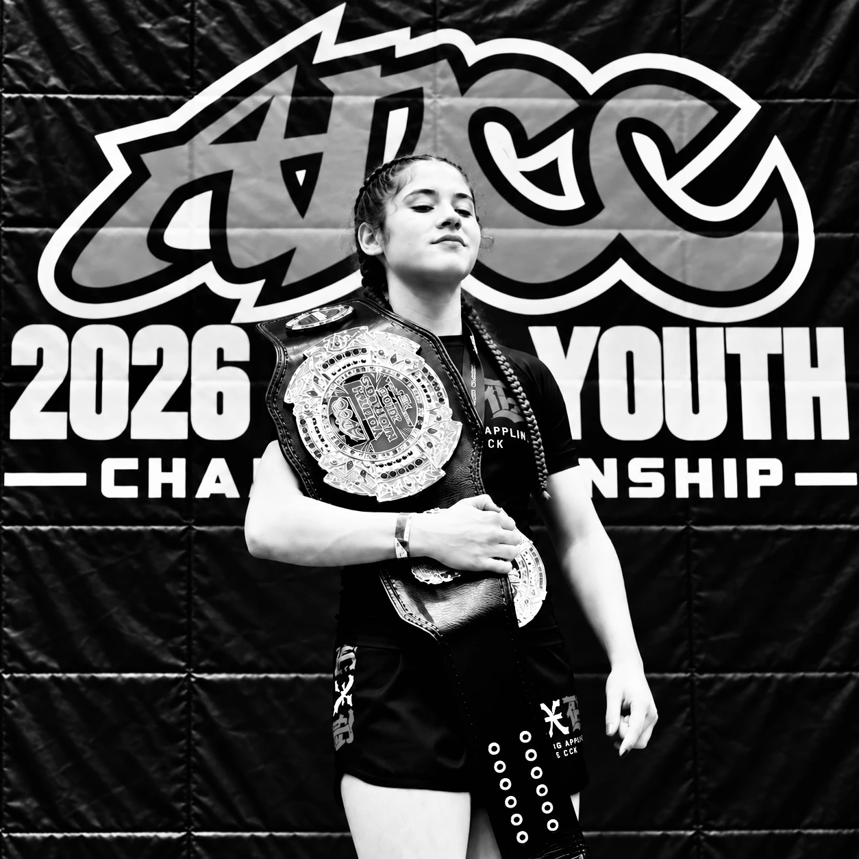 Young grappler holding an ADCC Youth World Championship belt