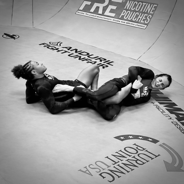 Two grapplers in a leg-lock exchange on the mat