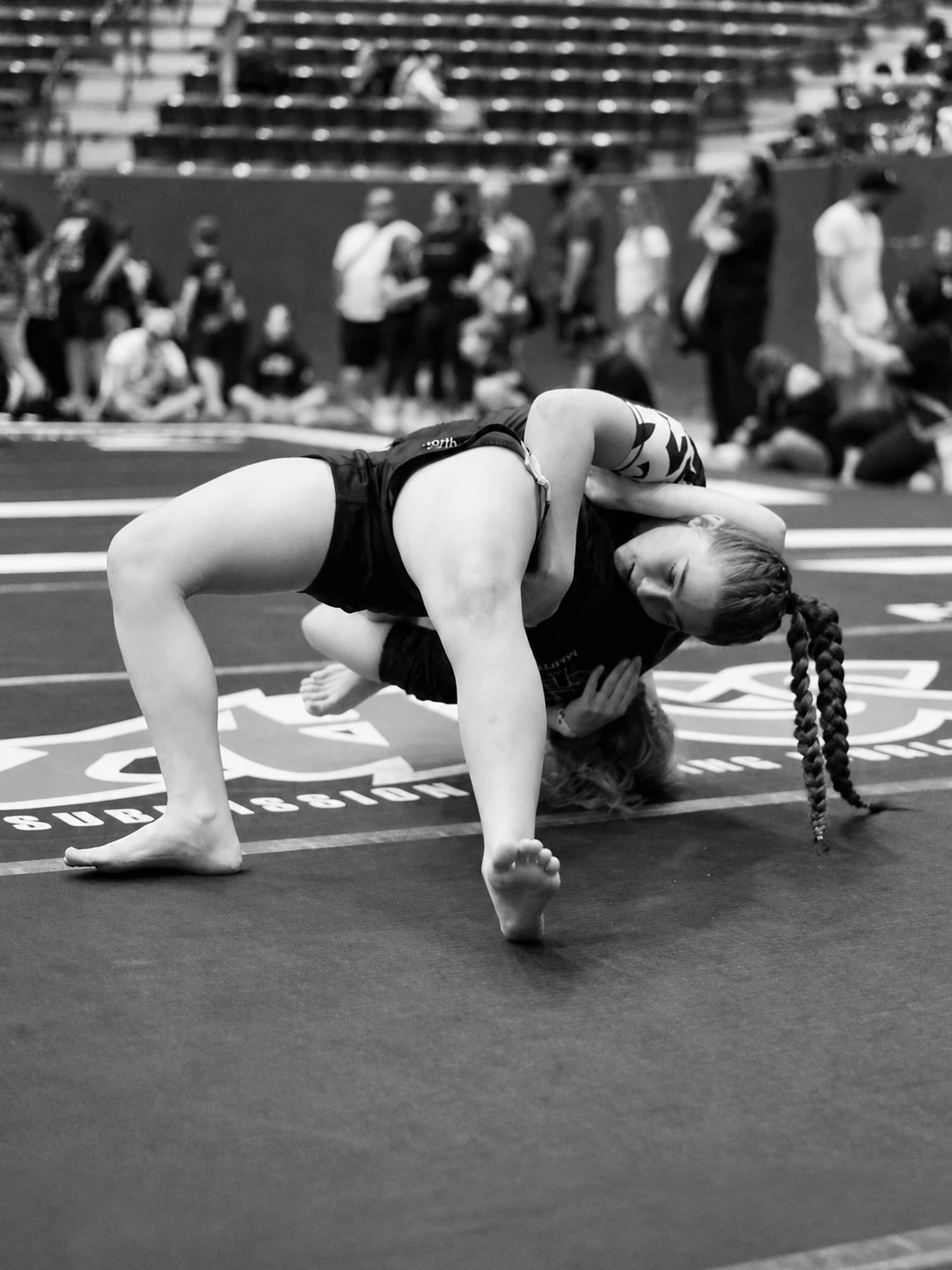 Two teenage girls grappling on the mat at the ADCC Austin Open