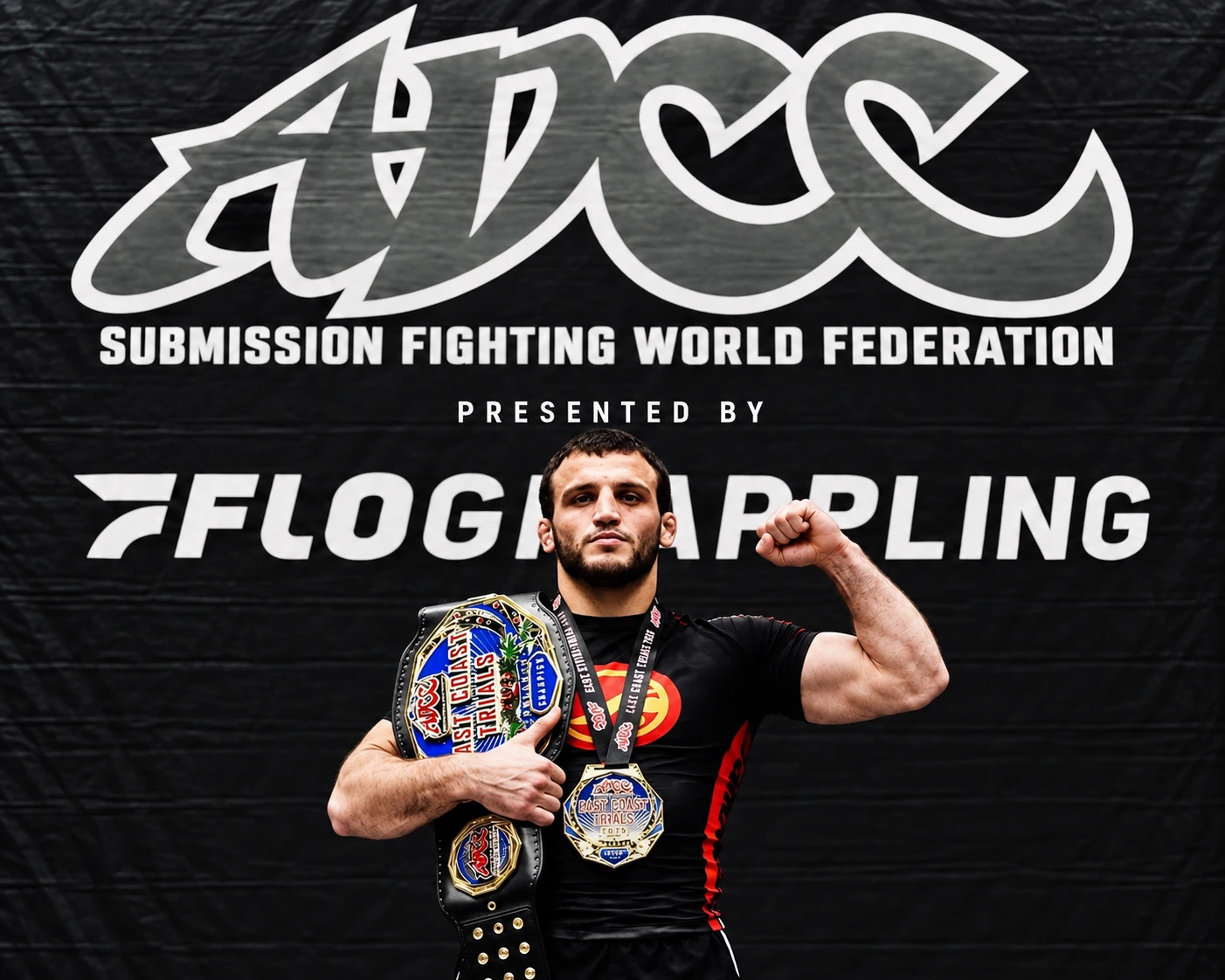 Grappler holding championship belts and medals in front of an ADCC backdrop